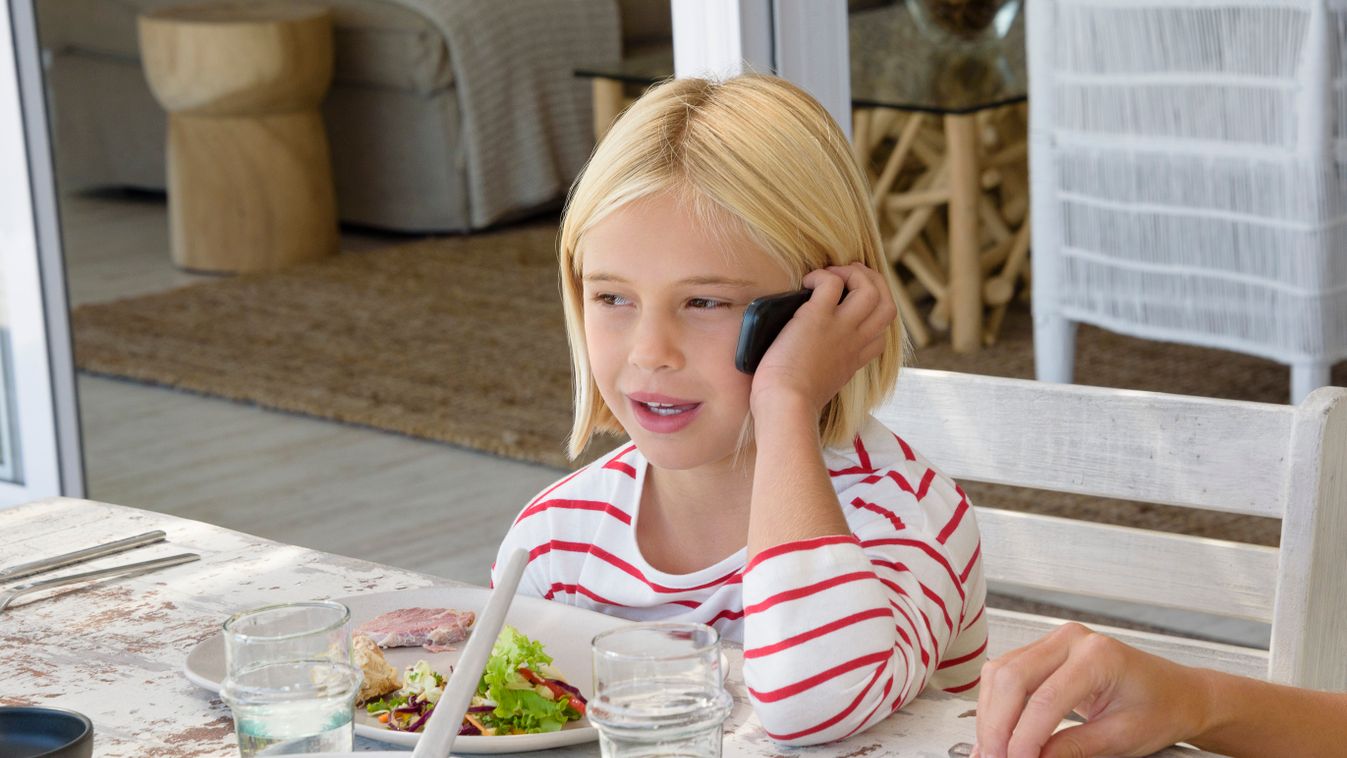 kislány mobil Little girl talking on mobile phone while eating meal Child Food Girls Home Talking Mobile Phone 8-9 Years Blond Hair Casual Clothing Caucasian Appearance Childhood Close-Up Color Image Communication Connection 
