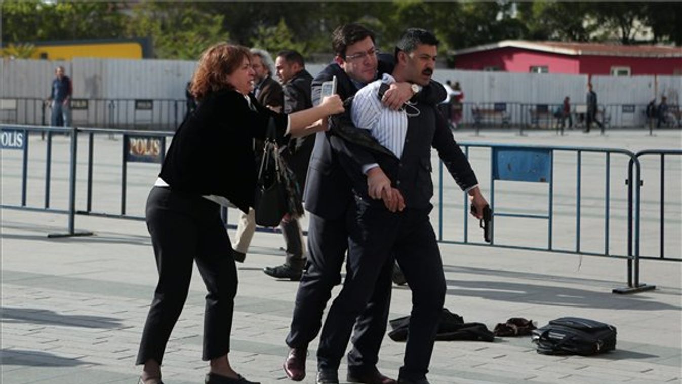 Can Dündar török ellenzéki újságíró felesége és Dündar ügyvédje (b2) lefognak egy fegyveres férfit, Murat Sahint, aki megtámadta a Cumhüriyet című lap főszerkesztőjét az isztambuli központi bíróság előtt 