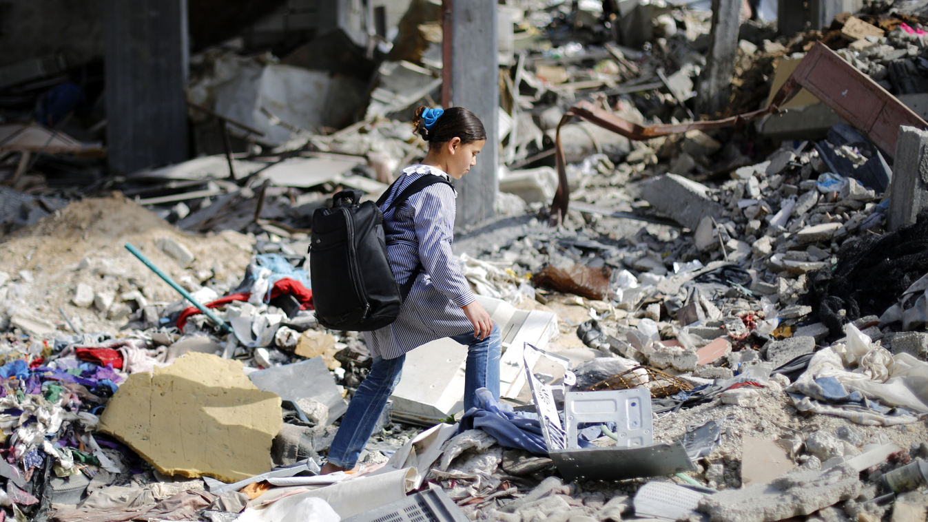 TOPSHOTS
A Palestinian school girl makes her way though the rubble of destroyed buildings as she heads home after school on March 11, 2015 in Beit Hanun in the northern of Gaza Strip. Qatar on March 11, 2015 launched a project to build 1,000 homes in the 