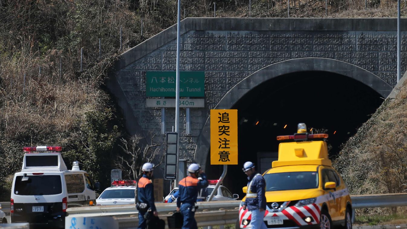 Horizontal Policemen gather at an entrance of the 860-metre (940-yard) Hachihonmatsu tunnel in Hiroshima prefecture on March 17, 2016. 
 A fiery multi-vehicle pileup inside a Japanese highway tunnel on March 17 killed at least two people and sent dozens f