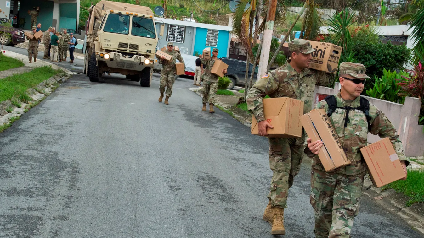 Horizontal In this image released by the US Department of Defense, soldiers assigned to Joint Task Force Puerto Rico and the Puerto Rico National Guard deliver cases of water and shelf-stable meals to residents of one of the most heavily damaged neighborh