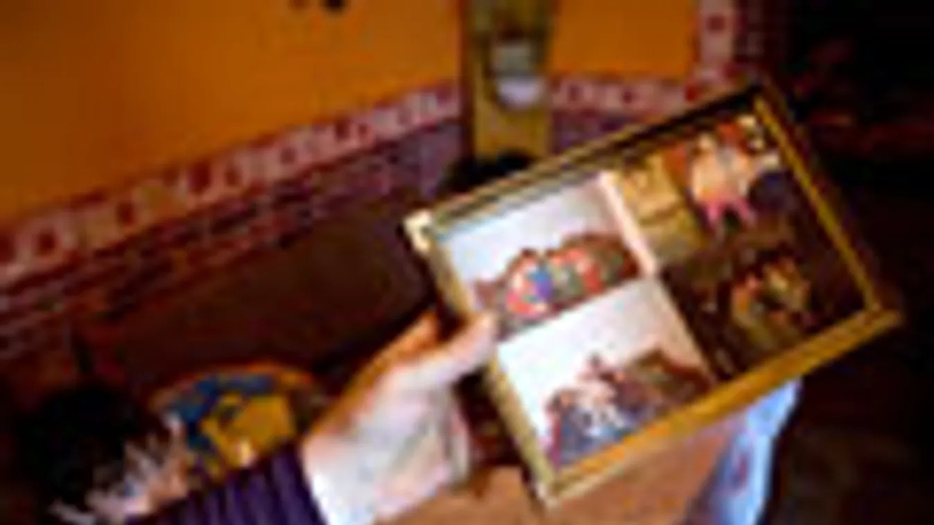 romagyilkosok büntetőpere, beharangozó, az áldozatok fényképét mutatja egy hozzátartozó Tatárszentgyörgyön 2009. február 24-én