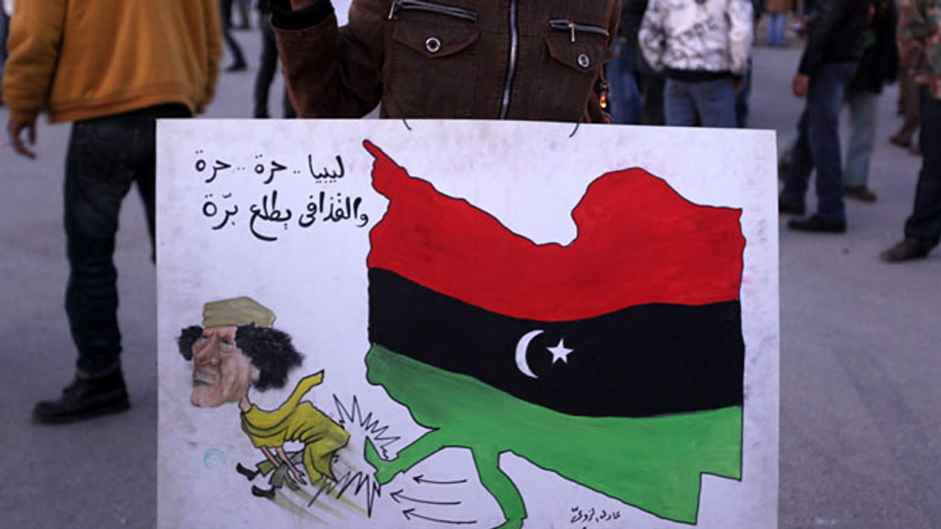 Egy tüntető Kadhafit ábrázoló táblája a Líbia keleti, felkelők által ellenőrzött részén fekvő Tobrukban 2011. február 24-én