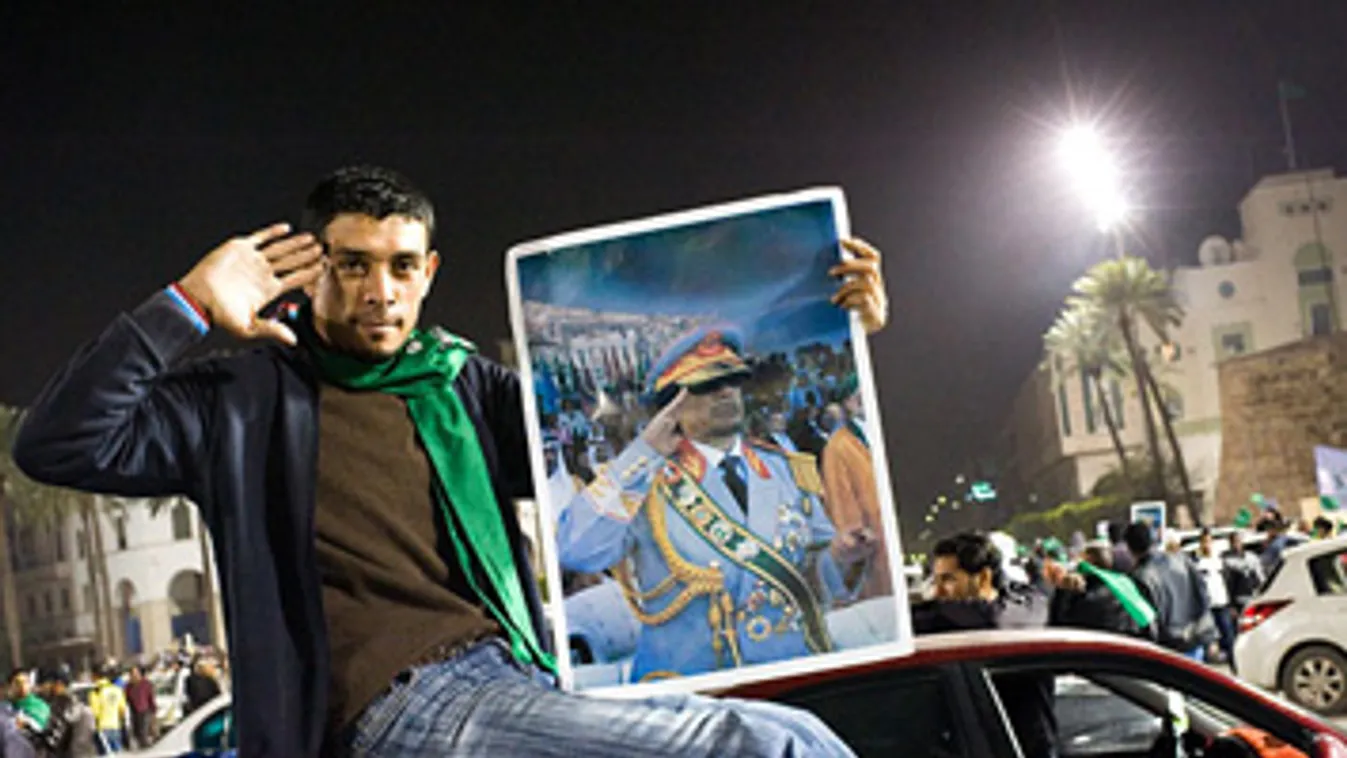 Líbia, kormányellenes tüntetések, Moammer Kadhafi líbiai vezető képét tartja a kezében egy kormánypárti ellentüntető