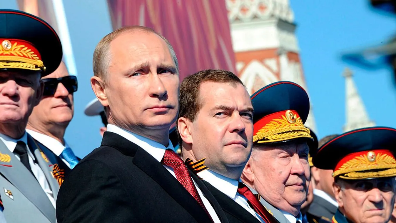 Vlagyimiri Putyin orosz elnök és Dmitrij Medvegyev tábornokaik gyűrűjében a parádén