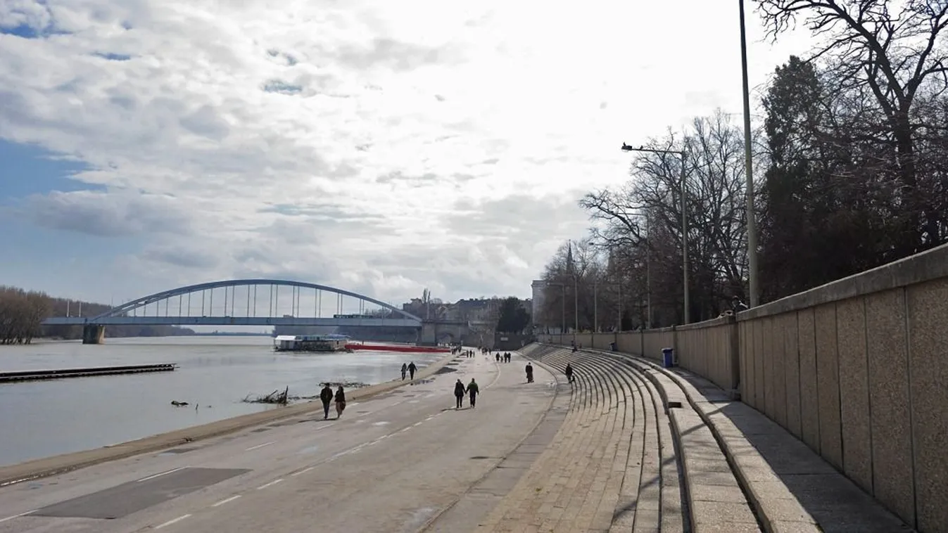 Járókelők sétálnak Szegeden a tavaszi napsütésben a Tisza áradása miatt a járműforgalom elől lezárt rakparton. 
