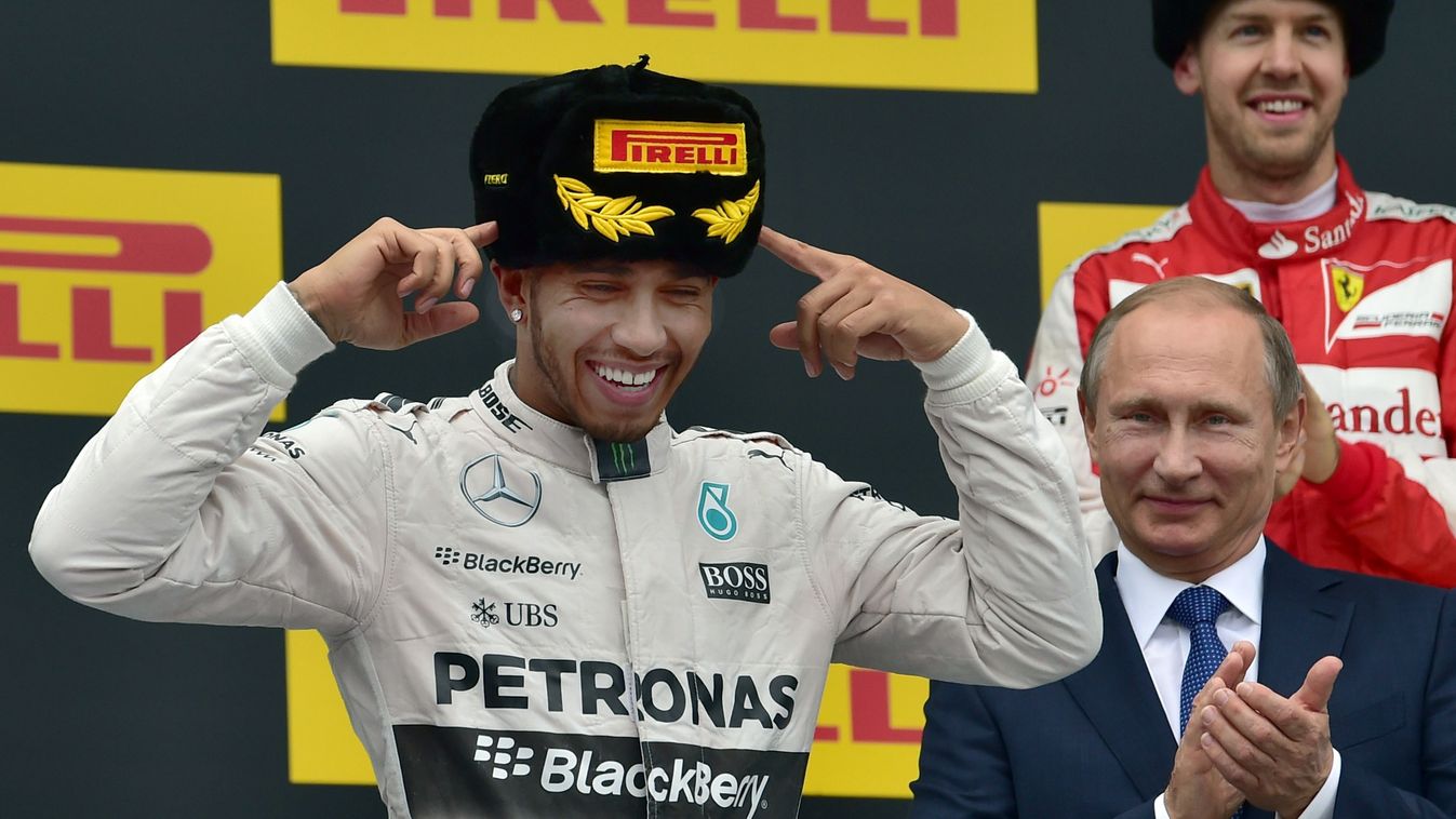 528111569 Mercedes AMG Petronas F1 Team's British driver Lewis Hamilton (L) celebrates his victory on the podium as Russian President Vladimir Putin (2nd R) and second placed Ferrari's German driver Sebastian Vettel stand behind after the Russian Formula 