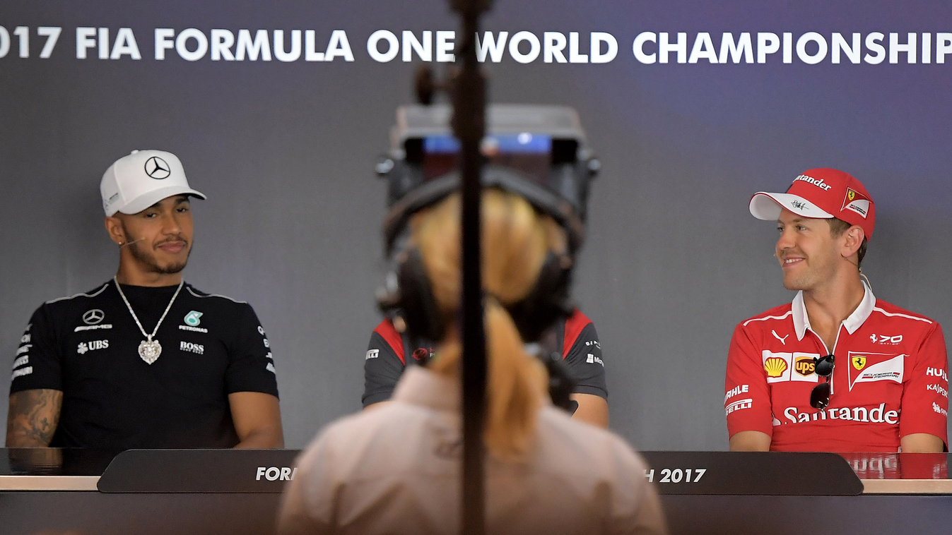 Horizontal panoramic Scuderia Ferrari's German driver Sebastian Vettel (R) and Mercedes AMG Petronas F1 Team's British driver Lewis Hamilton attend a press conference ahead of the Austrian Formula One Grand Prix on July 06, 2017. / AFP PHOTO / JOE KLAMAR 