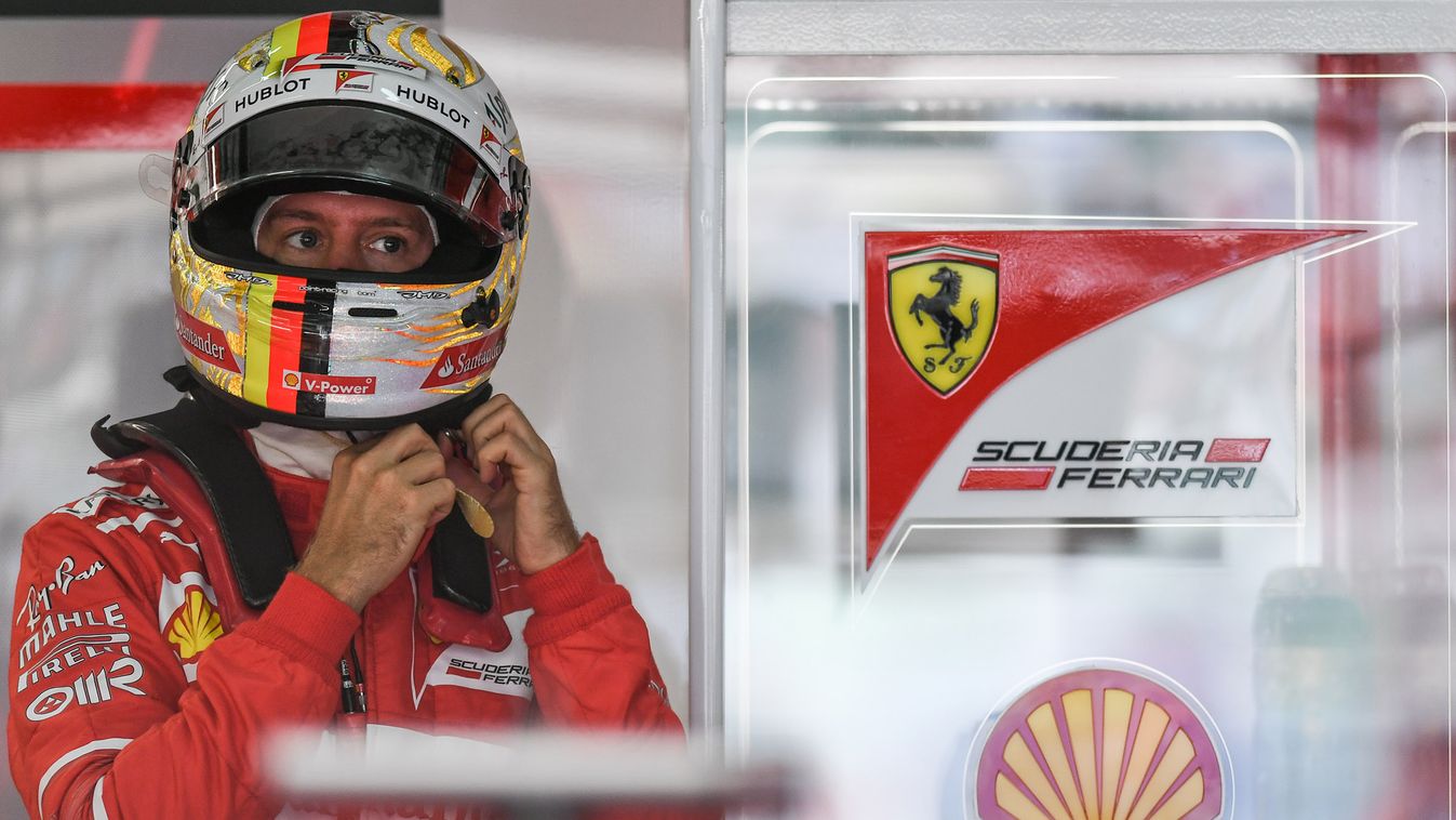 auto-prix Horizontal Ferrari's German driver Sebastian Vettel wears his helmet during the third practice session of the Formula One Malaysia Grand Prix in Sepang on September 30, 2017.  / AFP PHOTO / MOHD RASFAN 