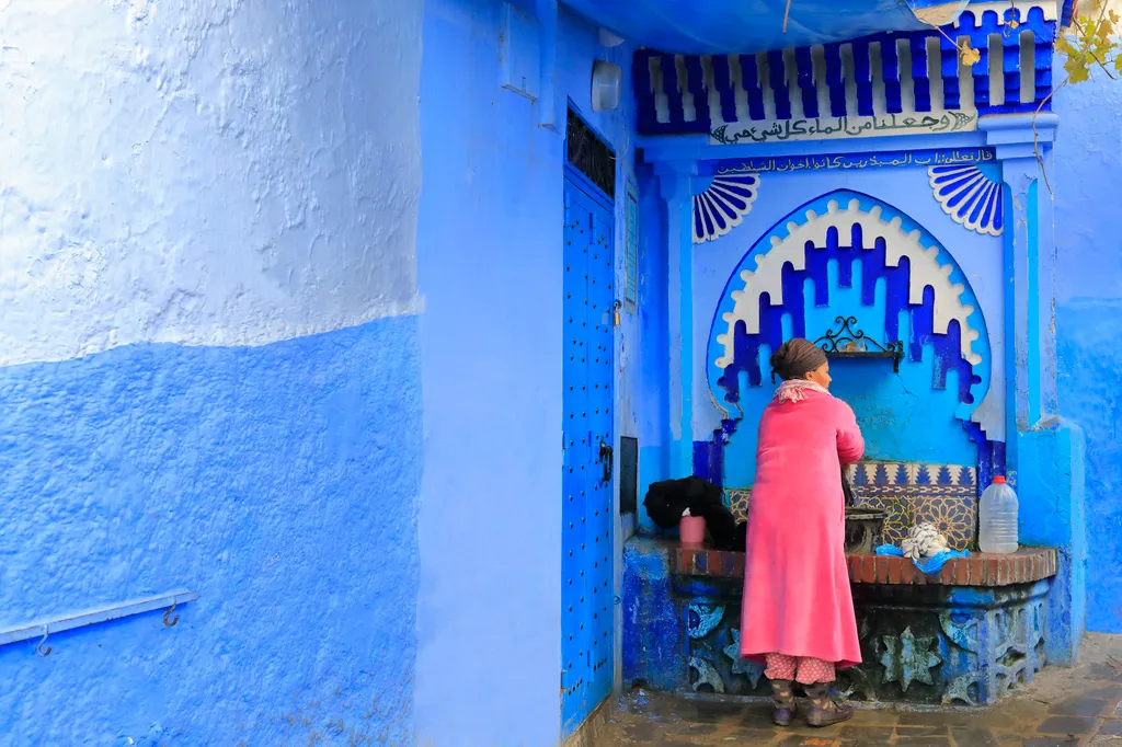 Morocco rif region chefchaouen medina woman washing clothes fountain