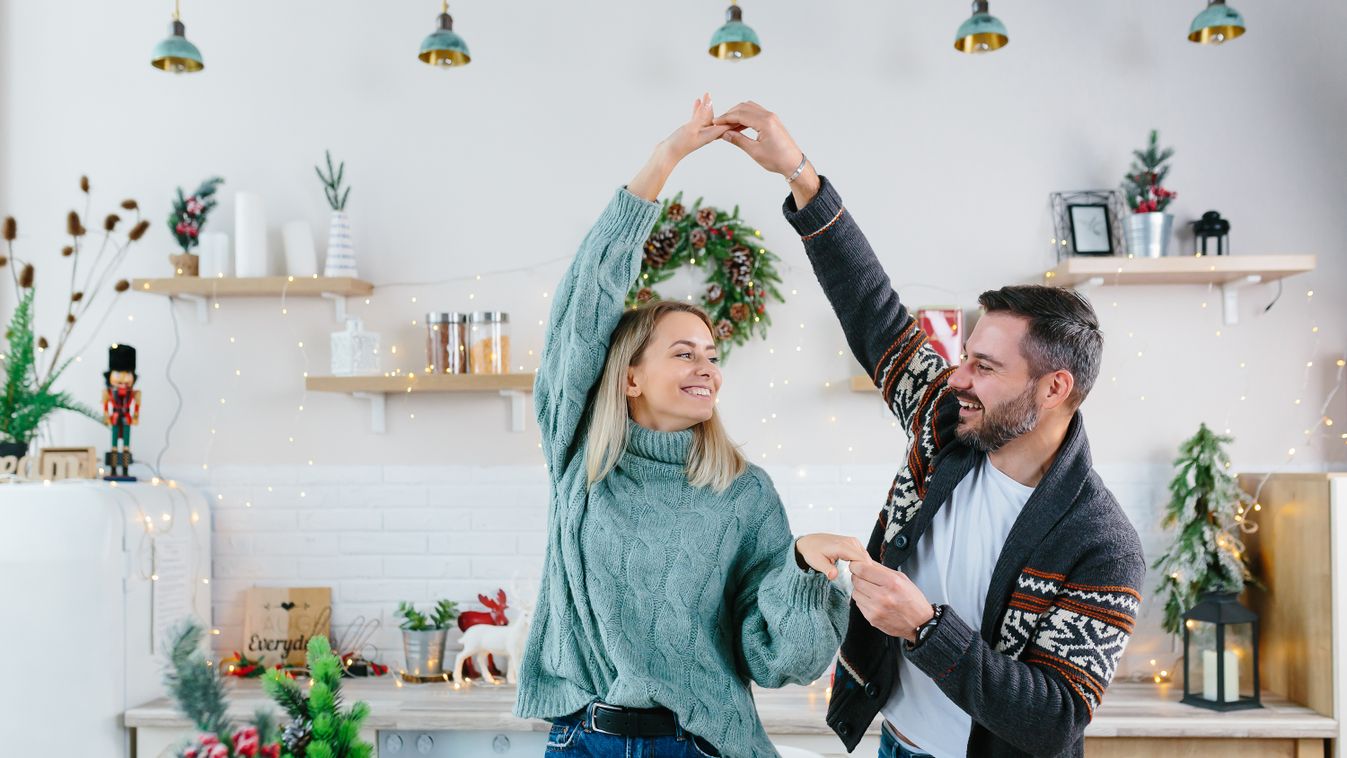 Young,Couple,Husband,And,Wife,Happy,Preparing,For,New,Year romance,couple,cozy,closeness,husband,merry,relation,music,embra Young couple husband and wife happy preparing for New Year and Christmas celebration, family having fun dancing in the kitchen 
