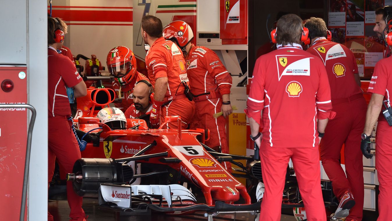 Horizontal Ferrari's German driver Sebastian Vettel (L) waits for repair at the pit during the Formula One Japanese Grand Prix at Suzuka on October 8, 2017.  / AFP PHOTO / POOL / KAZUHIRO NOGI 