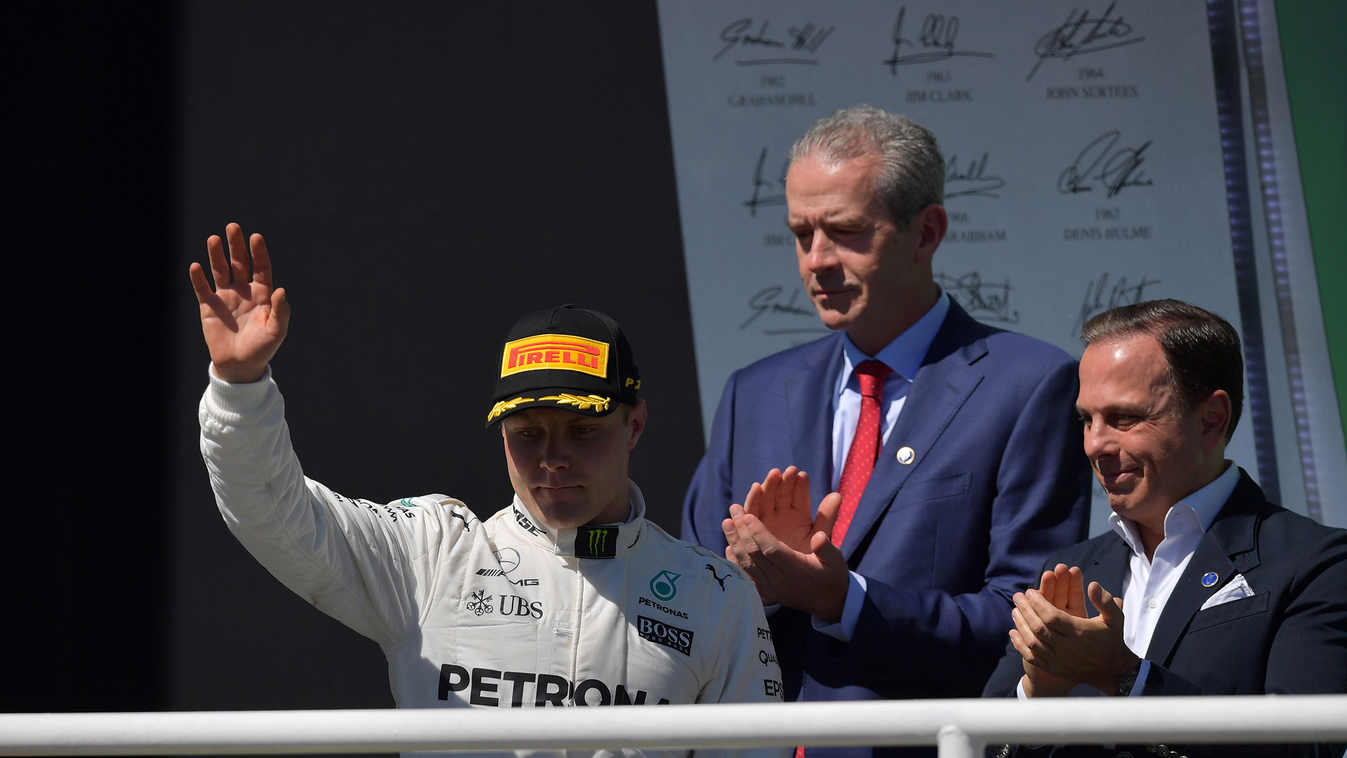 687715911 auto-f1 auto Horizontal Runner-up Mercedes' Finnish driver Valtteri Bottas waves at the crowd from the podium after the Brazilian Formula One Grand Prix, at the Interlagos circuit in Sao Paulo, Brazil, on November 12, 2017. / AFP PHOTO / Carl DE