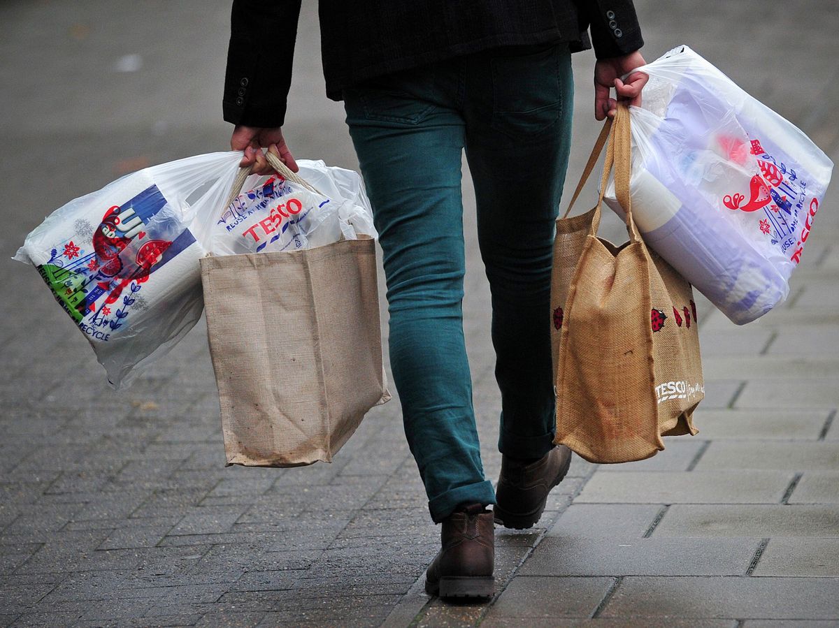 Egy vásárló csomagjaival távozik egy londoni Tesco áruházból