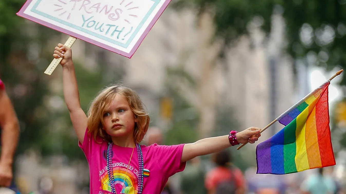A child is seen with a sign that reads: "Protect Trans Youth" in the Annual New York