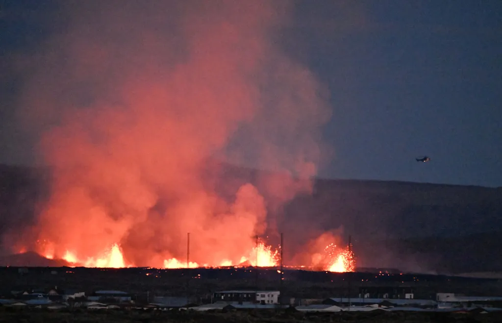 Vulkánkitörés Izland, vulkán, 2024.01.15.,  explosions and smoke near residential buildings in the southwestern Icelandic town of Grindavik after a volcanic eruption on January 14, 2024. Seismic activity had intensified overnight 