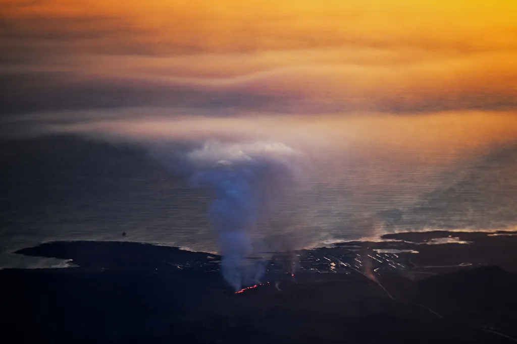 Vulkánkitörés Izland, vulkán, 2024.01.15.,  lava explosions and billowing smoke near residential buildings in the southwestern Icelandic town of Grindavik after a volcanic eruption on January 14, 2024. Seismic activity 