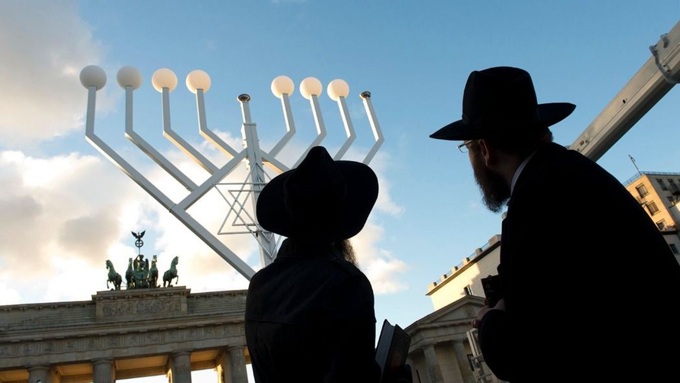 Két rabbi figyeli a Brandenburgi kapu előtt felállított óriási menórát, amely az egyik legnagyobb zsidó ünnep, a hanuka jelképe