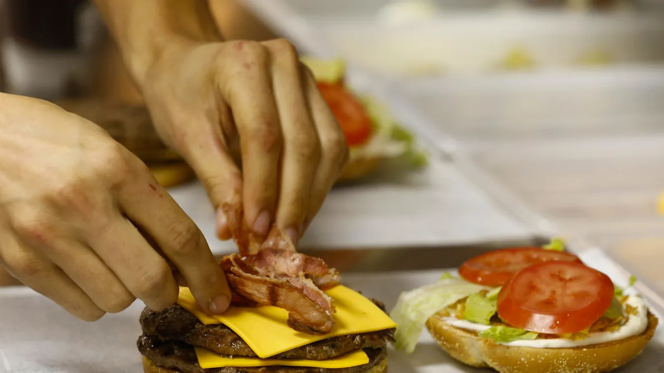 Egy dolgozó a Burger King egyik szendvicsét készíti a cég egyik gyorséttermében (illusztráció)