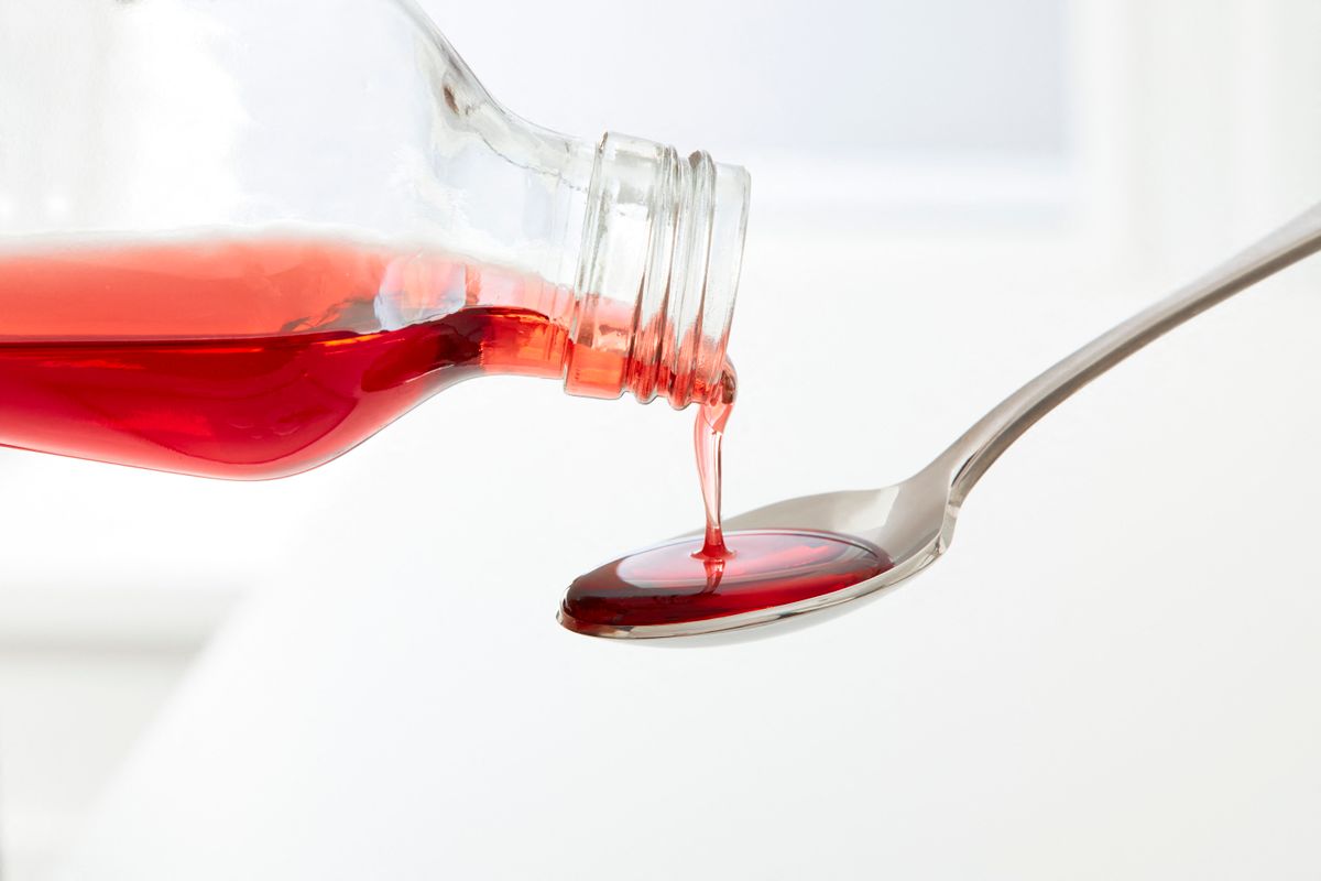 Cough syrup pouring onto a spoon