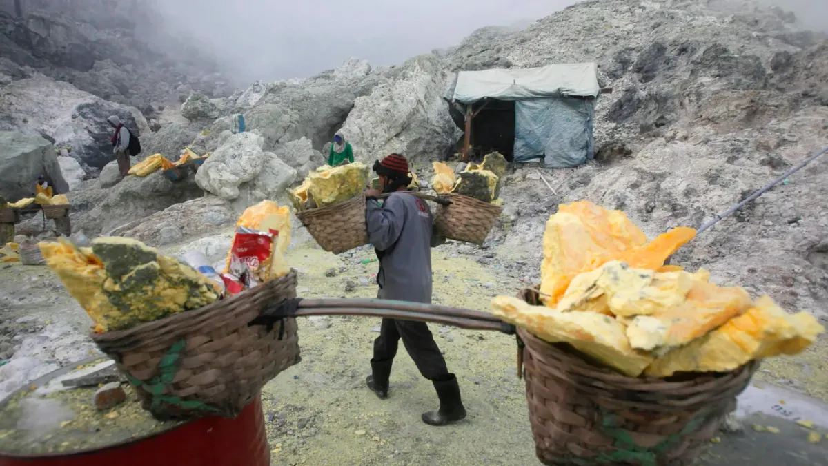 Indonéz kénbányászok hordanak nyers kéndarabokat egy lelőhelyen, a kelet-jávai Banyuwangi kormányzóságban fekvő Ijen hegyén. Az Ijen-hegy 2800 méteres tengerszint feletti magasságával Jáva szigetének népszerű turista célpontja, amelynek mérgező gázokat kibocsátó vulkanikus kürtőjébe éjjelente kénbányászok százai ereszkednek le, hogy hátukon cipelve felszínre hozzák a sárga kristálytömböket, melyeket ezer indonéz rúpia (mintegy 190 forint) kilónkénti áron vásárolnak fel tőlük.