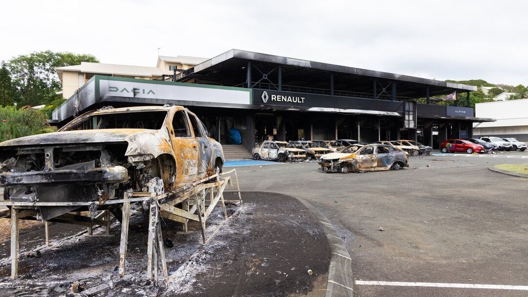 Kiégett autóroncsok egy tüntetők által felgyújtott autókereskedés előtt az új-kaledóniai fővárosban, Nouméában 2024. május 22-én.