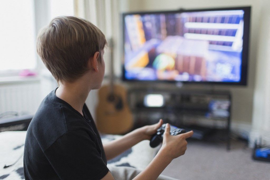 Boy playing video game at TV in living room