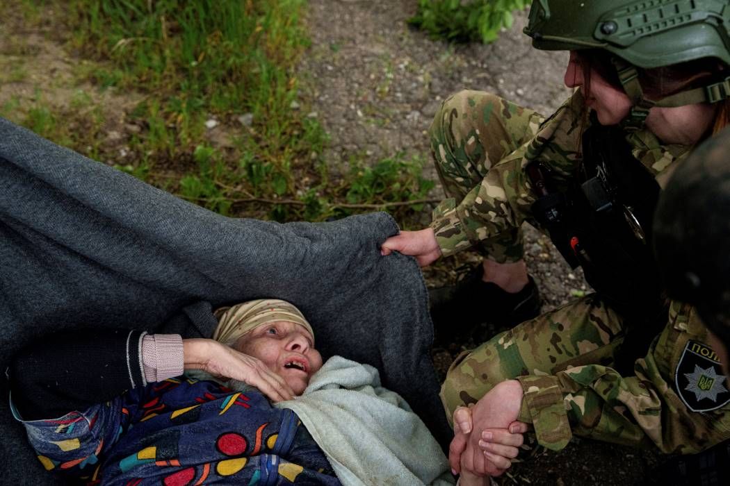 Vovcsanszk, 2024. május 11. Idős asszonyt menekítenek ki otthonából egy orosz légicsapás után a Harkiv megyei Vovcsanszk településen 2024. május 11-én. MTI/AP/Jevhen Maloletka