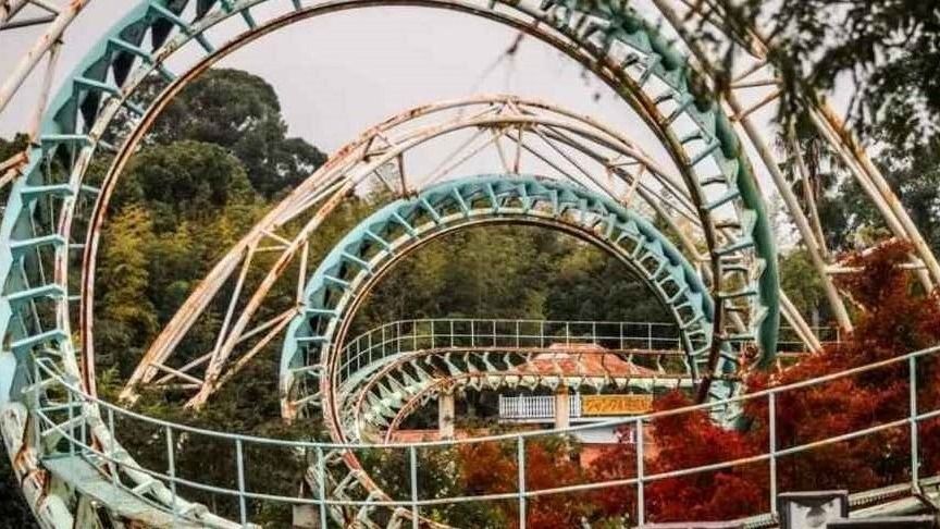 Rollercoaster at abandoned theme park Nara Dreamland with autumn leaves