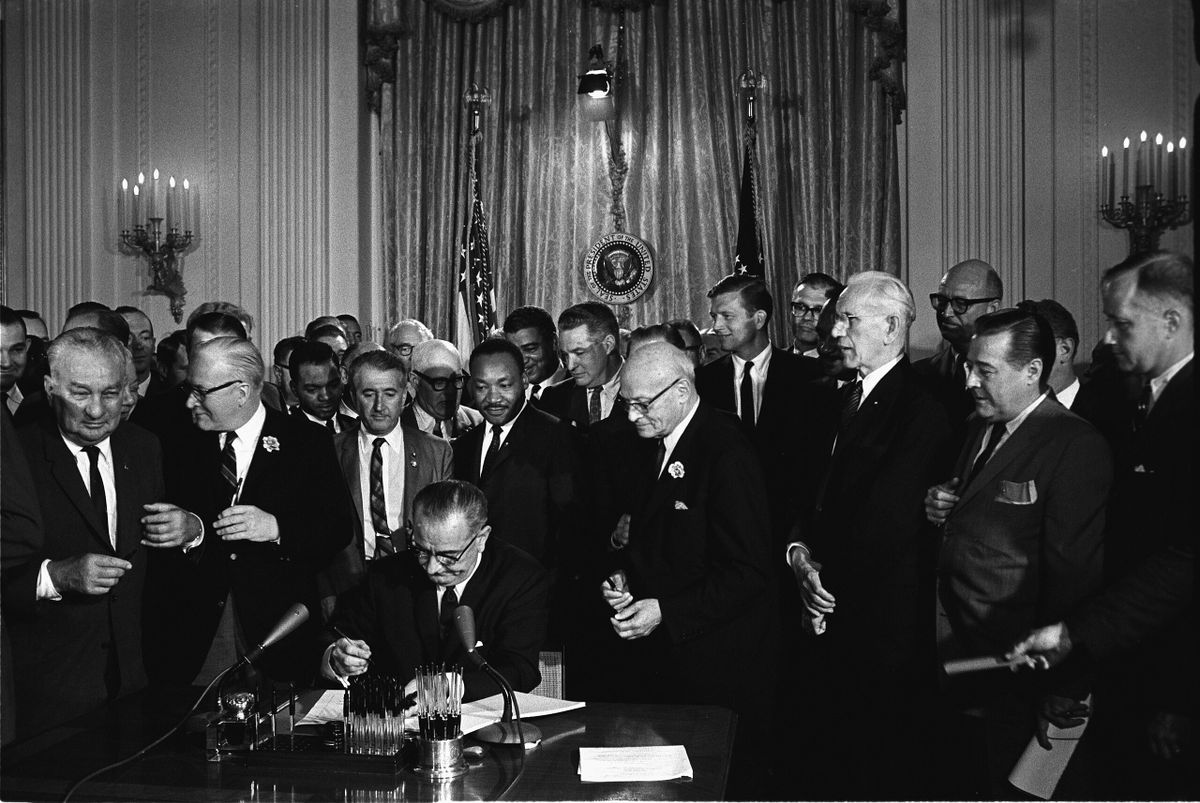 Az amerikai polgárjogi törvény aláírása 1964-ben, ami megtiltotta a faji, vallási, etnikai alapú, valamint a nők elleni diszkriminációt