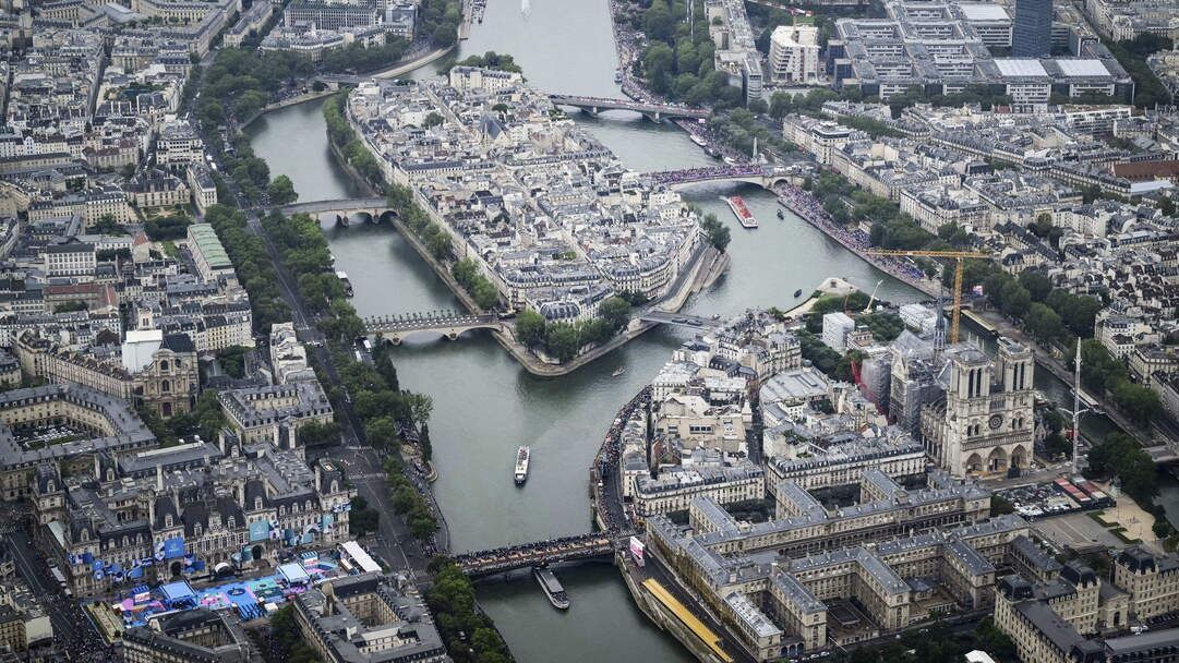 Párizs, 2024. július 26. Légi felvétel az olimpiai csapatokat szállító hajókról a Szajna folyón a 2024-es párizsi nyári olimpia megnyitóünnepségén 2024. július 26-án. Jobbról a Notre Dame-székesegyház. MTI/AP/AFP pool/Lionel Bonaventure