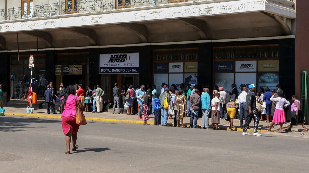 harare, zimbabwe, Emberek állnak sorban Hararéban egy banknál, hogy amerikai dollárhoz jussanak a korábbi készpénzhiány idején (illusztráció)