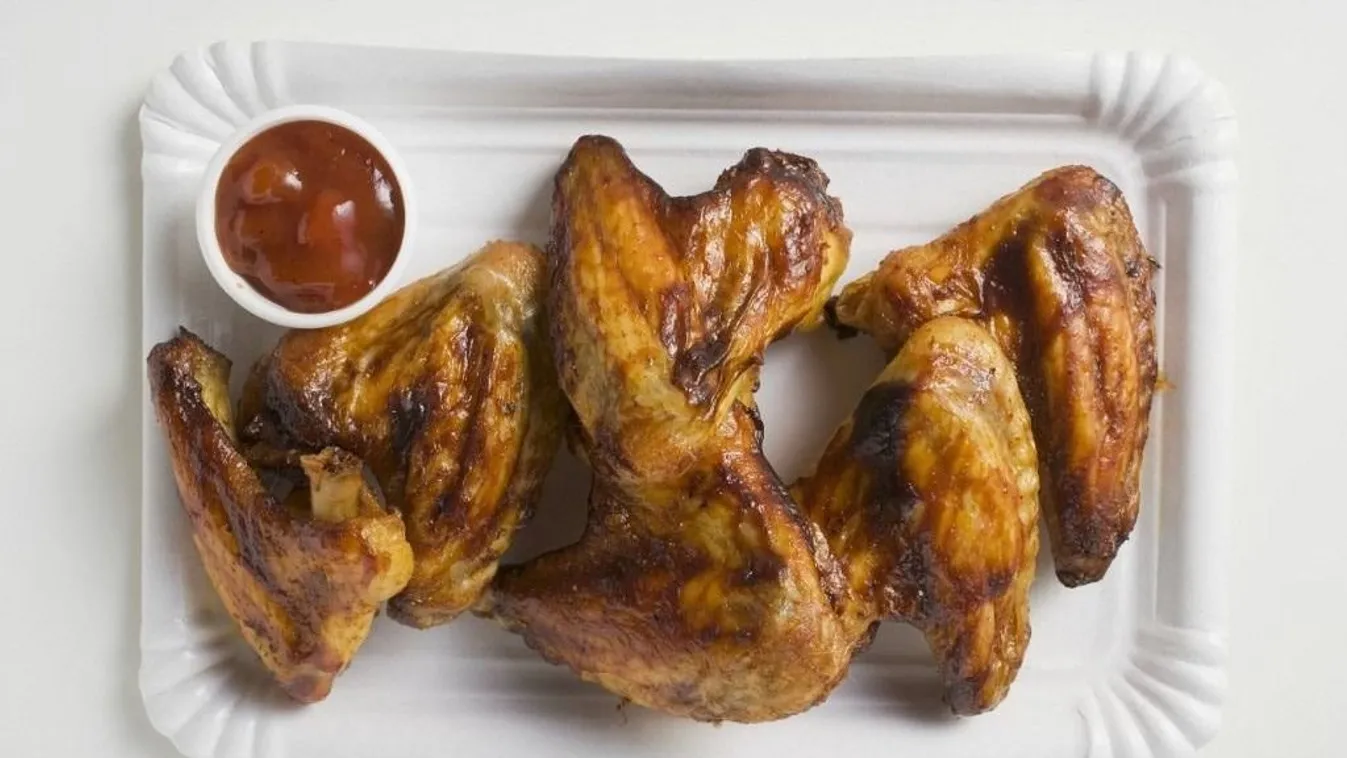 Grilled chicken wings with ketchup on paper plate