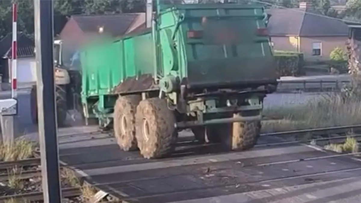 A vasúti átjáró közepén akadt le a traktor pótkocsija, óriási sebességgel tarolta le a vonat - videó
