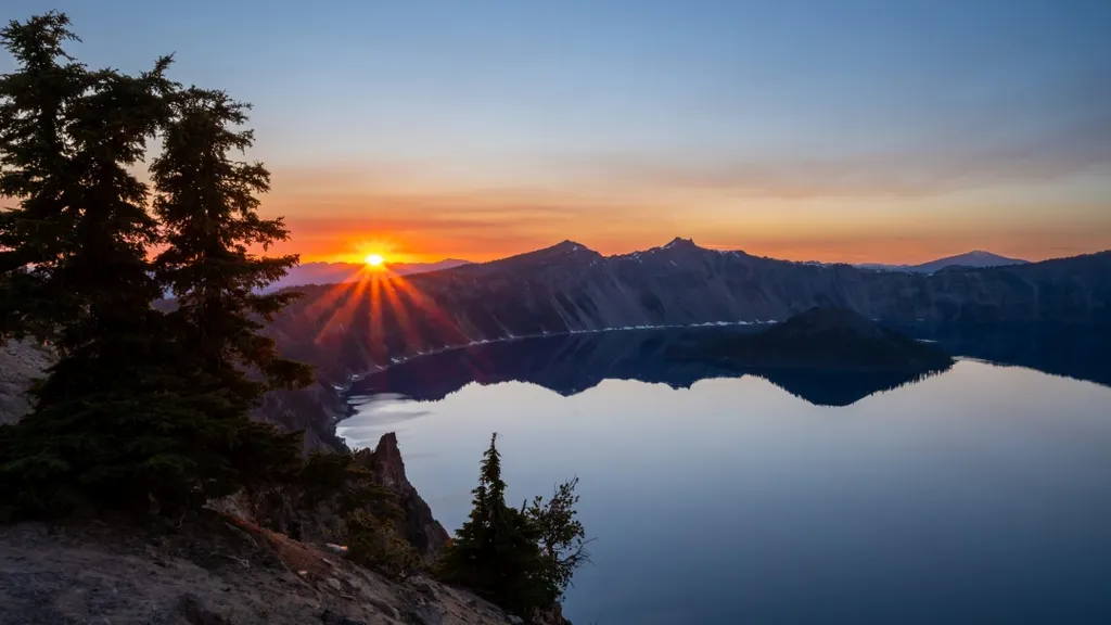 Orange,Rays,From,Sunset,Behind,Mountains,Over,Crater,Lake,National