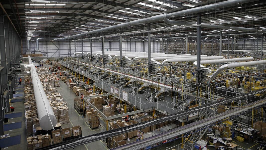 Workers work inside an Amazon.co.uk fulfillment centre in Hemel Hempstead, north of London, on November 25, 2015. Shops could be seeing the effect of consumers postponing purchases until "Black Friday" on November 27, a day of sales in the United States that has become increasingly popular in Britain. AFP PHOTO / ADRIAN DENNIS / AFP PHOTO / Adrian DENNIS