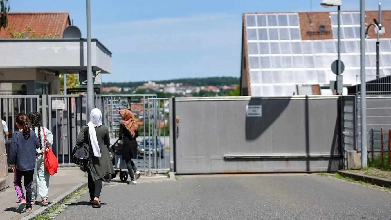 A menekültek és a migránsok a menedékkérők központi befogadóközpontja előtt Bajorországban