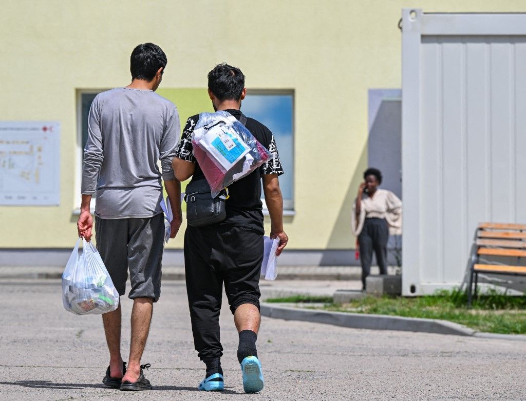 Két migráns sétál át a menedékkérők központi befogadó központja (ZABH) területén Brandenburg államban