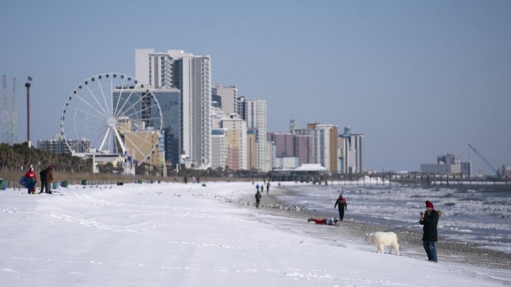 Emberek felfedezik a havat a tengerparton 2025. január 22-én a dél-karolinai Myrtle Beachen