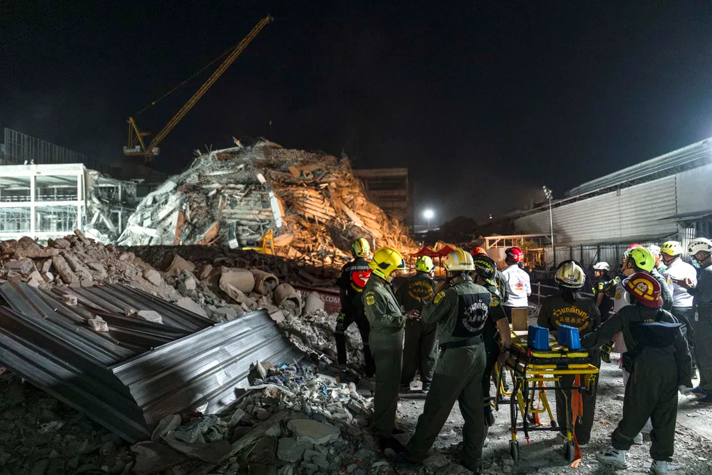 Rescue teams arrive with a stretcher to evacuate an injured man at a construction site where a building collapsed in Bangkok on March 28, 2025, following an earthquake. A powerful earthquake killed more than 20 people across Myanmar and Thailand on March 