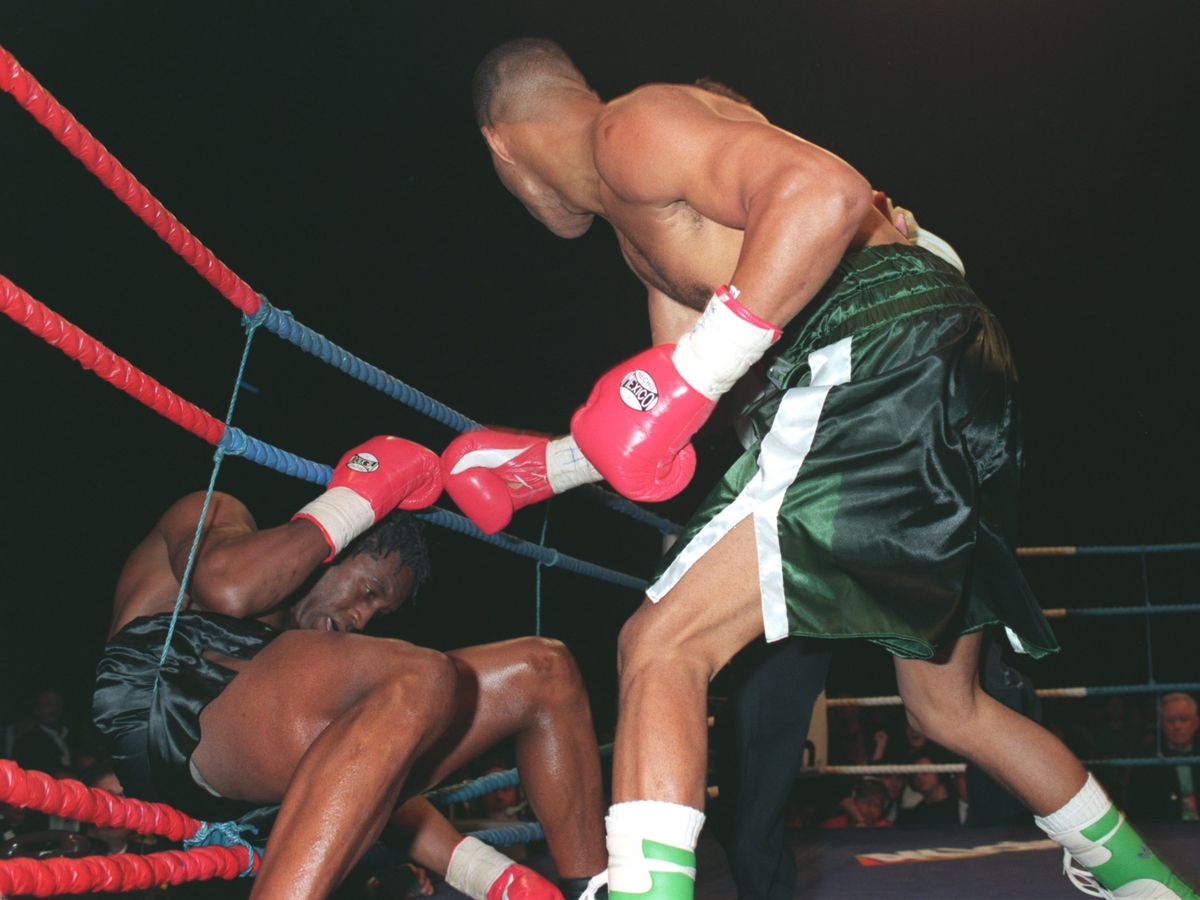 Gerald McClellan, GeraldMcClellan, 1995, GeraldMcClellan1995, 25 FEB 1995:  GERALD MCCLELLAN OF THE USA KNOCKS NIGEL BENN OF GREAT BRITAIN THROUGH THE ROPES DURING THEIR WBC SUPER MIDDLWEIGHT FIGHT AT THE LONDON ARENA, DOCKLANDS. Mandatory Credit: Ben Radford/ALLSPORT
