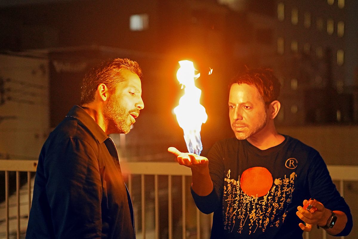 Cyril Takayama (wearing the David mask) demonstrates his fire hand trick for David Blaine. (credit: National Geographic/Dana Hayes)