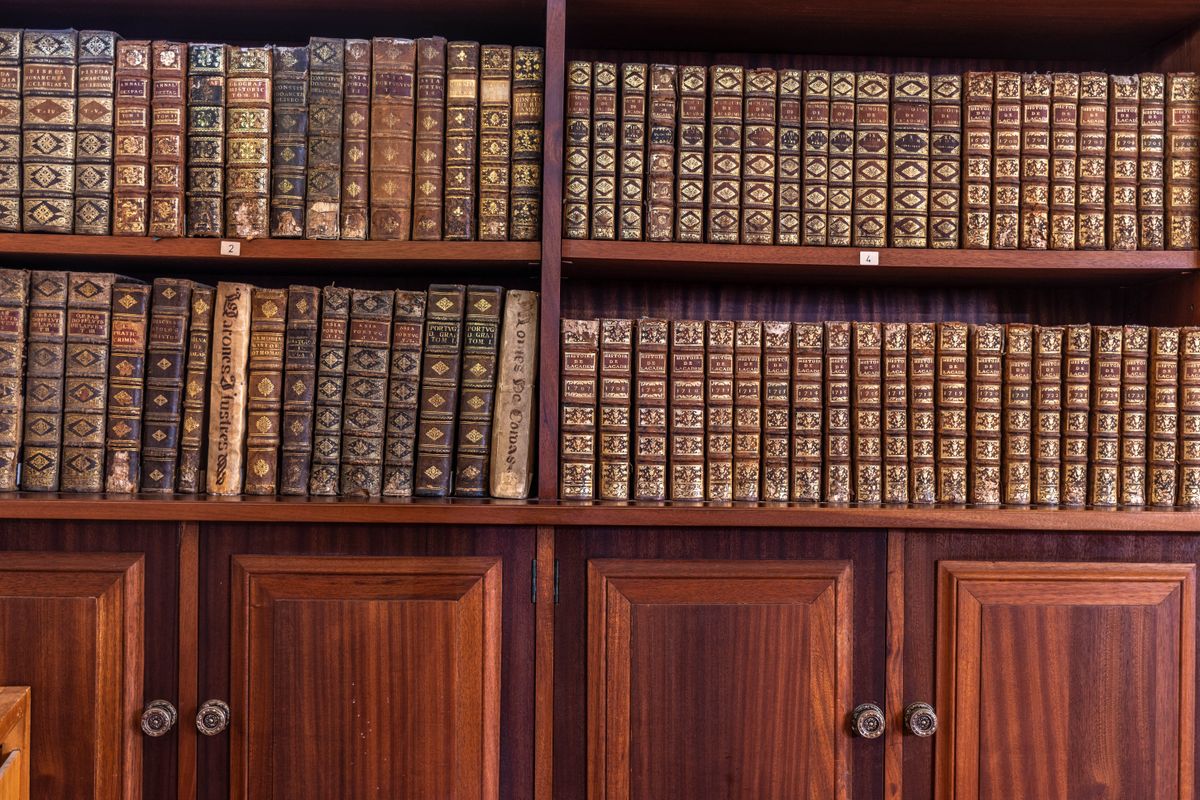 August 12, 2019. Coimbra. Portugal. University of Coimbra. A library cabinet with old books on the shelves.