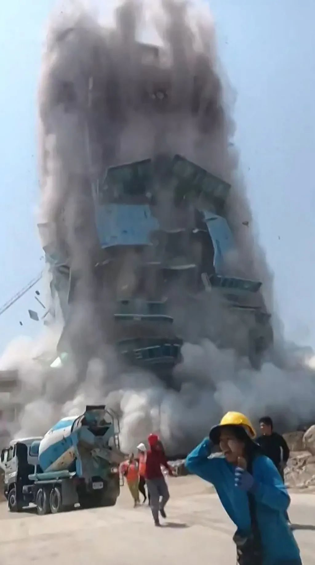 This frame grab from UGC video footage taken and posted by Khon Su Cheevit Adeet Mai Suay Rok Na on Facebook on March 28, 2025 shows workers running away from a building as it collapses at a construction site in Bangkok, following an earthquake. A powerfu
