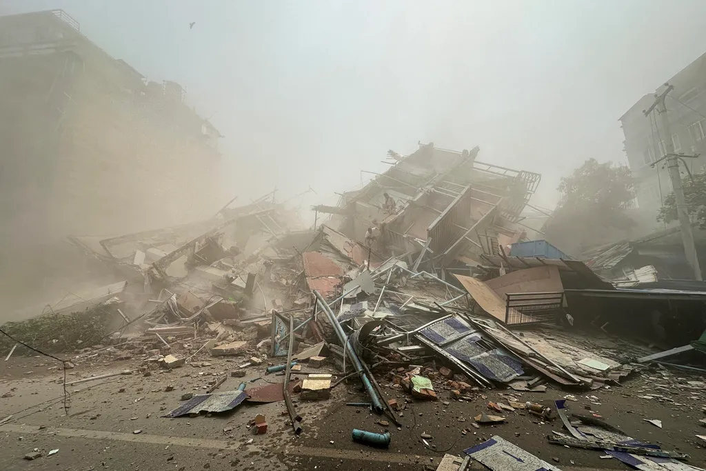 People inspect the debris of a collapsed building in Mandalay on March 28, 2025, after an earthquake. A powerful earthquake killed more than 20 people across Myanmar and Thailand on March 28, toppling buildings and bridges and trapping over 80 workers in 