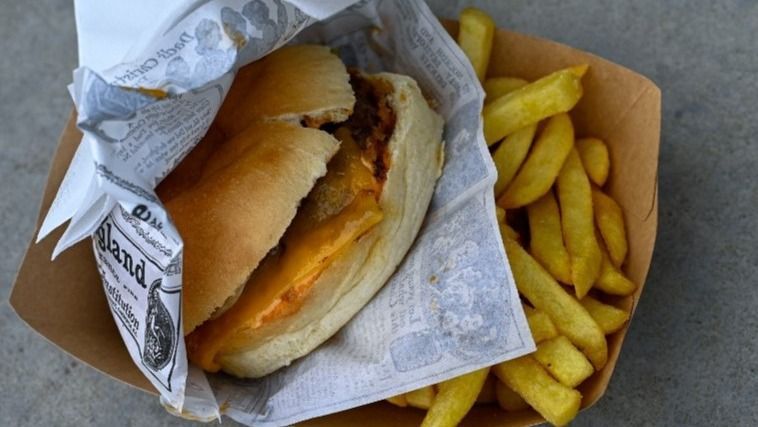 A burger and fries are placed on a table during the SIRHA International Catering, Hotel and Food Trade Exhibition at Eurexpo Lyon in Chassieu France on January 24 2025. (Photo by Matthieu Delaty / Hans Lucas / Hans Lucas via AFP)