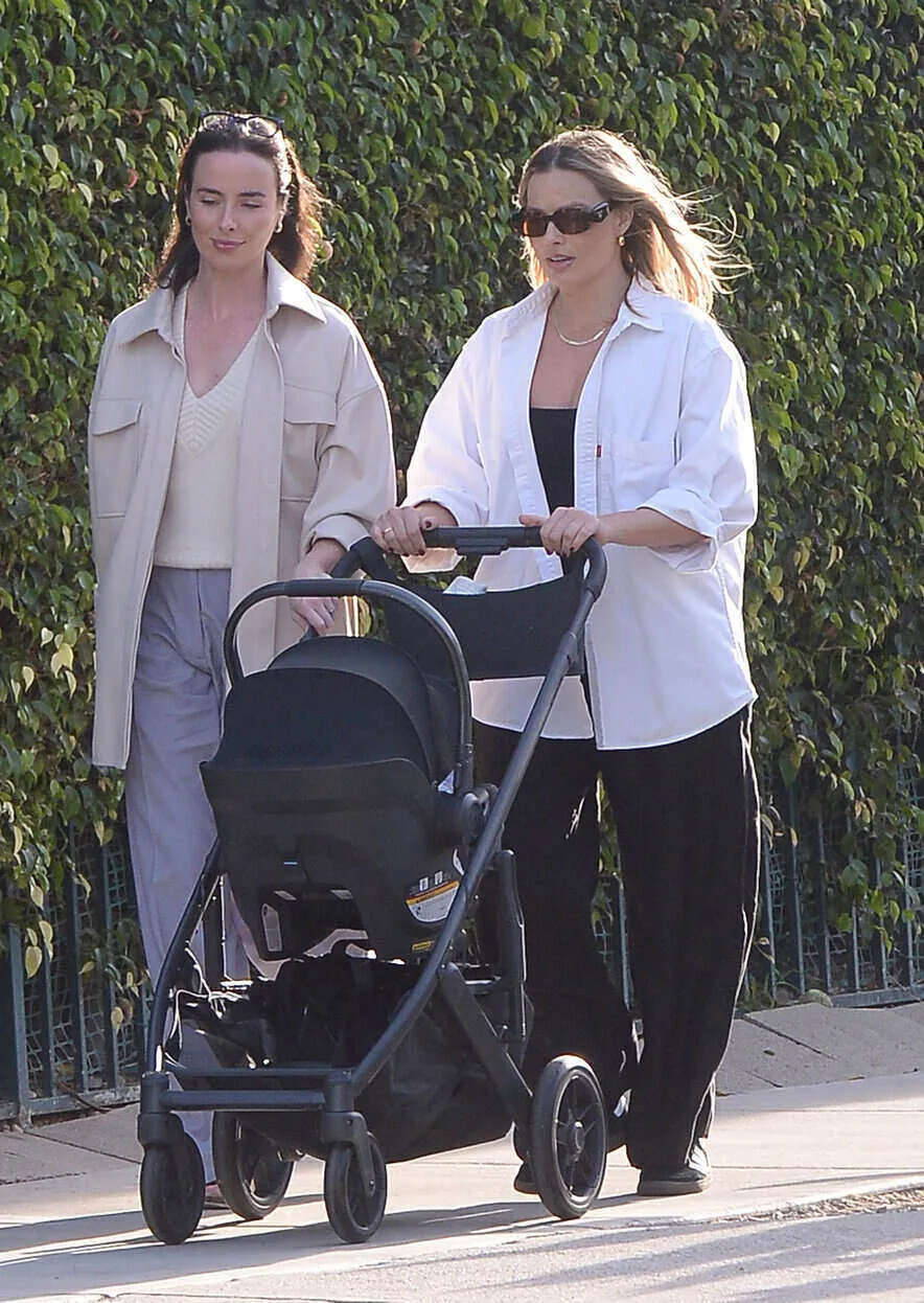 11/06/2024 Margot Robbie is spotted out for a stroll with her newborn in Los Angeles. The 34 year old actress who just announced this week that she and her husband Tom Ackerley welcomed their first child together was pictured out with her good friend Australian actress Ashleigh Brewer. Margot wore a white blouse paired with black joggers and black Adidas trainers.sales@theimagedirect.com Please byline:TheImageDirect.com