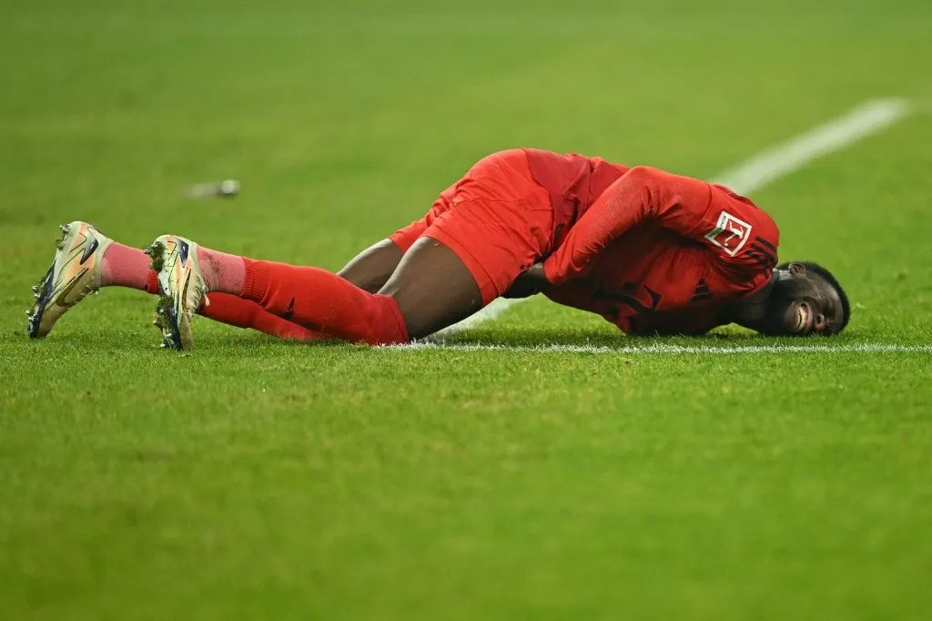 (FILES) Bayern Munich's Canadian defender #19 Alphonso Davies reacts as he lies on the pitch during the German first division Bundesliga football match between Borussia Dortmund and FC Bayern Munich in Dortmund, western Germany on November 30, 2024. Bayern Munich are facing the prospect of battling for both the league title and the Champions League without key players Dayot Upamecano and Alphonso Davies, who returned from international duty injured, the German giants said on March 26, 2025. (Photo by INA FASSBENDER / AFP) / DFL REGULATIONS PROHIBIT ANY USE OF PHOTOGRAPHS AS IMAGE SEQUENCES AND/OR QUASI-VIDEO