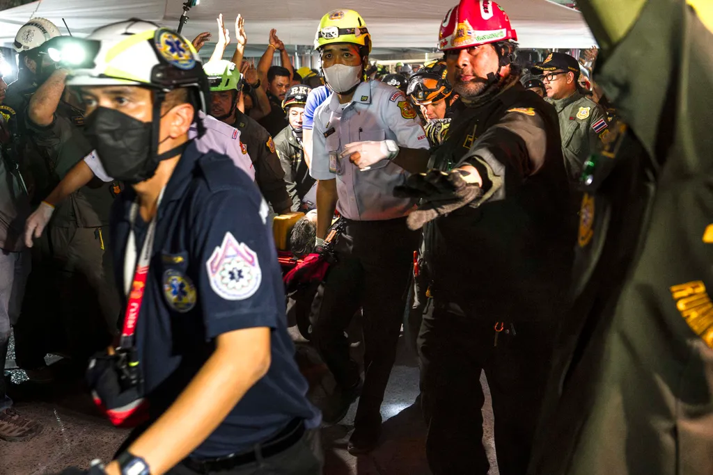 Rescue teams evacuate an injured man in a stretcher at a construction site where a building collapsed in Bangkok on March 28, 2025, following an earthquake. A powerful earthquake killed more than 20 people across Myanmar and Thailand on March 28, toppling