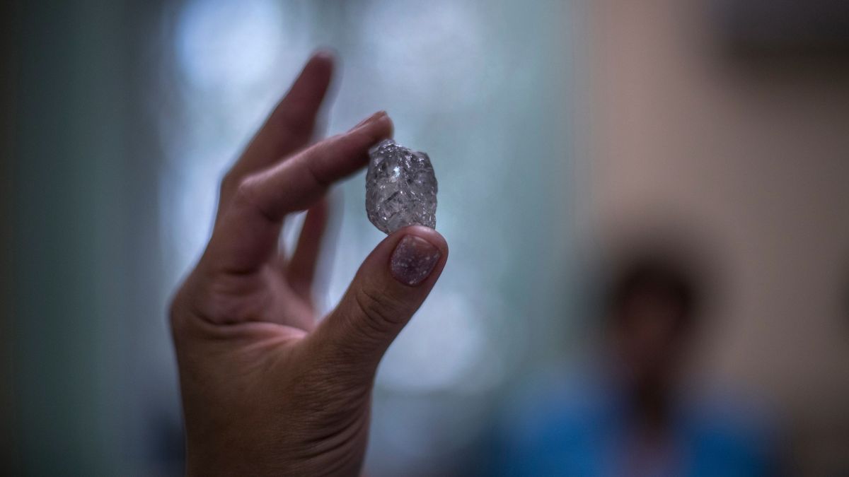 Mirnij, 2019. július 3. A 2019. június 19-i képen nyersgyémántot mutat egy dolgozó az Alrosa orosz gyémántipari társaság központjában, a jakutföldi Mirnijben. A Mirnijnél levő 525 méter mély és 1200 méter széles külfejtés, a Mir (Béke) a bolygó felszínének egyik legnagyobb mesterséges mélyedése. A 2001-ben bezárt bányát az Alrosa 2009-ben újranyitotta felszín alatti kitermelésre. Az Alrosa az oroszországi gyémánt 95 százalékát, világszinten pedig a gyémántkitermelés 27 százalékát adja. A mintegy 37 ezer embert foglalkoztató vállalat jelenleg 12 kimberlitkürtőnél és 16 üledékes lerakódásnál végez kitermelést Jakutföldön és az Arhangelszki területen. MTI/EPA/Szergej Ilnyickij